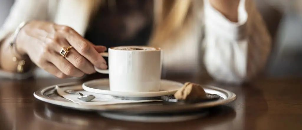 Lady's hand holding a coffee cup.