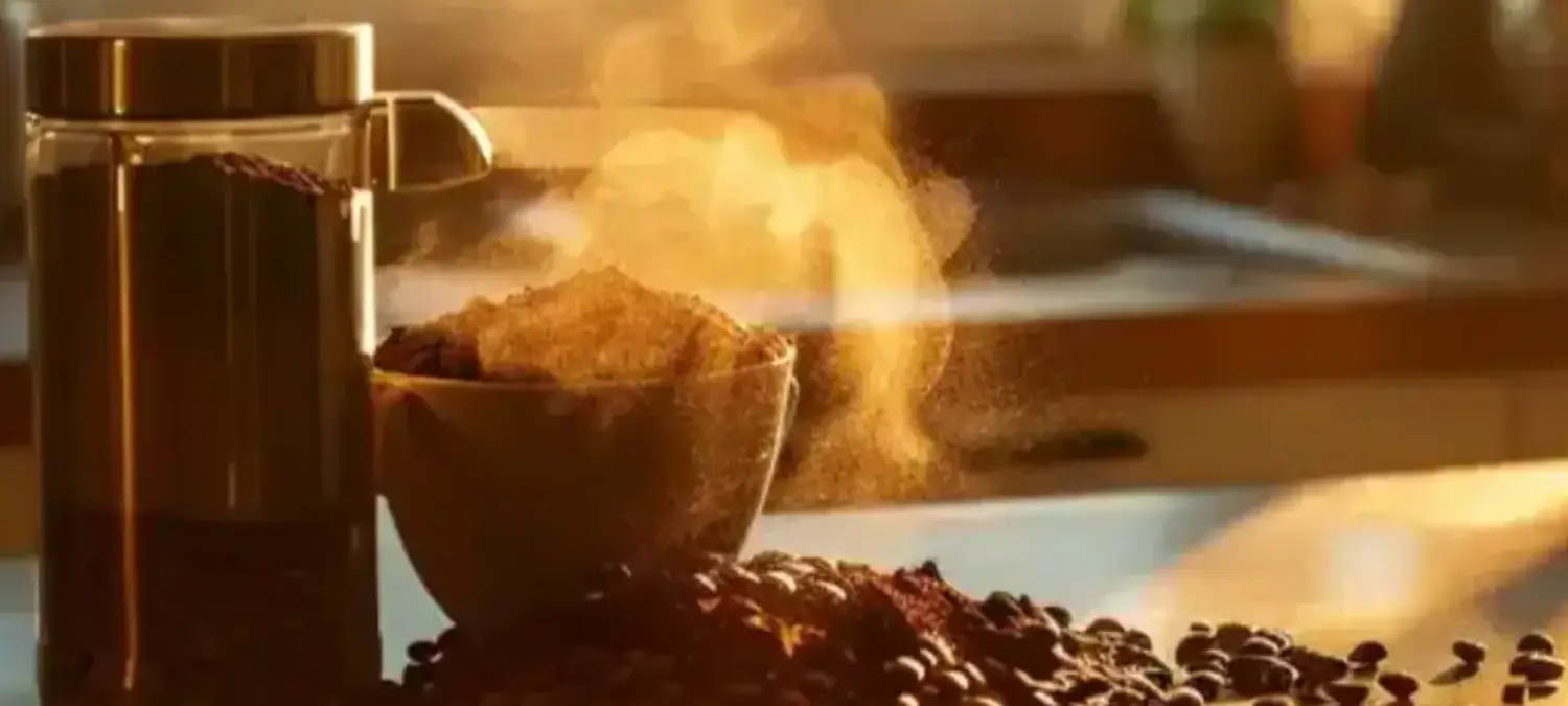 Best Espresso Grinders for Home Baristas in 2026 β 2 Espresso grinder next to a pile of freshly ground coffee beans on a countertop