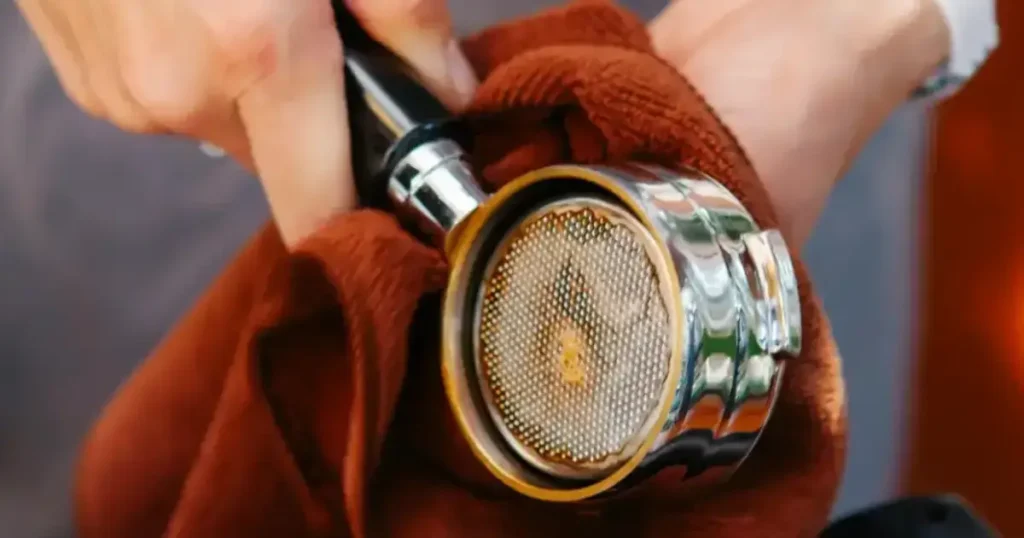 Espresso Shot Screen: What It Is & Why It Matters ☕ 8 Detailed view of an espresso shot screen in baristas hand during cleaning
