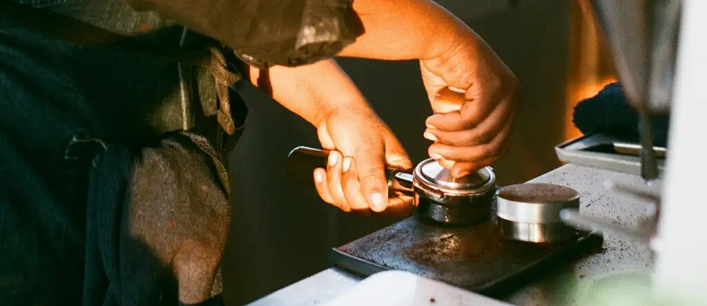 A barista applying the correct techniques during tamping