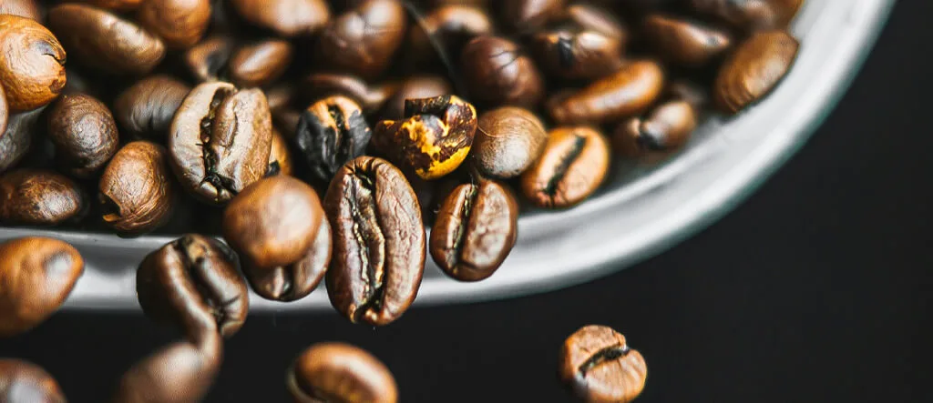 Close-up of coffee beans, highlighting the different factors like origin, roast level, and freshness to consider when choosing beans for espresso.