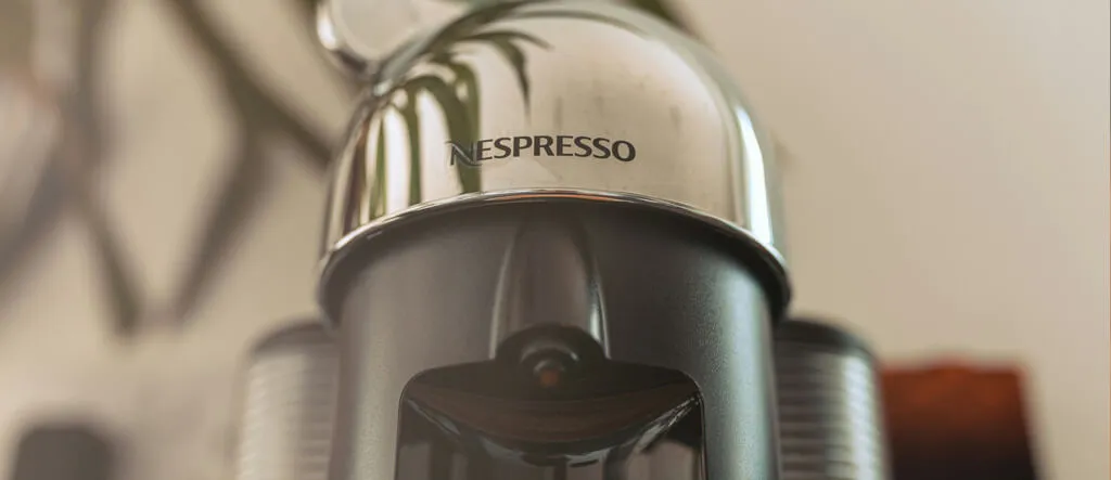 Top view of a pod espresso machine showing the water reservoir and control panel.