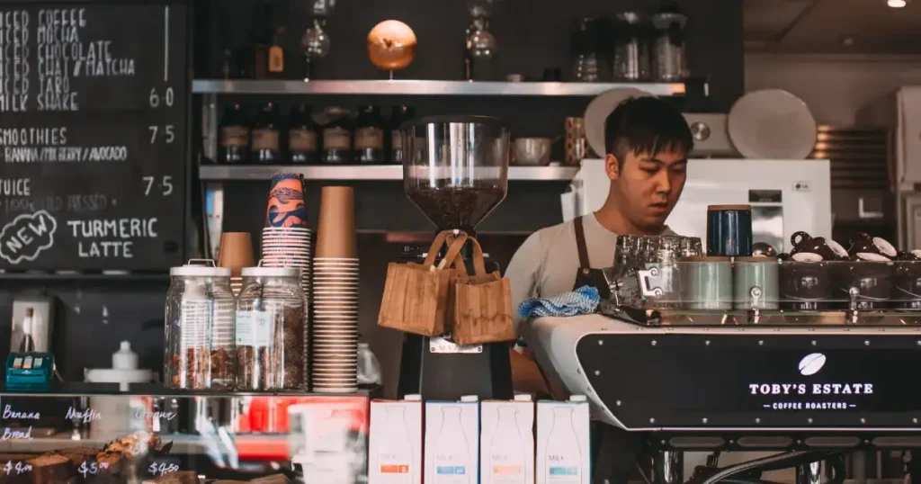 Barista Equipment - Essential Tools Coffee Lovers Will Love 70 A barista preparing coffee with professional tools, illustrating essential espresso barista equipment for home use