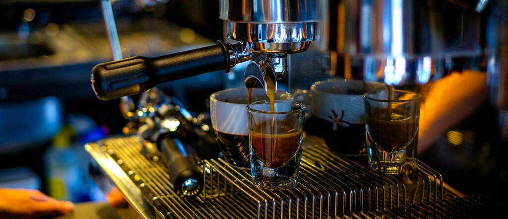 Close-up of espresso pouring from an espresso machine into a glass cup