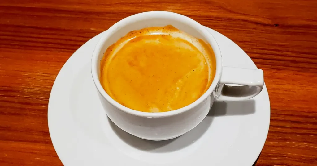 Espresso Crema - What It Is & Why It Matters ☕ 4 Rich golden creamy espresso crema on top of a cup of hot coffee. Ready to be enjoyed