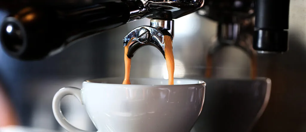 Espresso being extracted from a machine into a cup