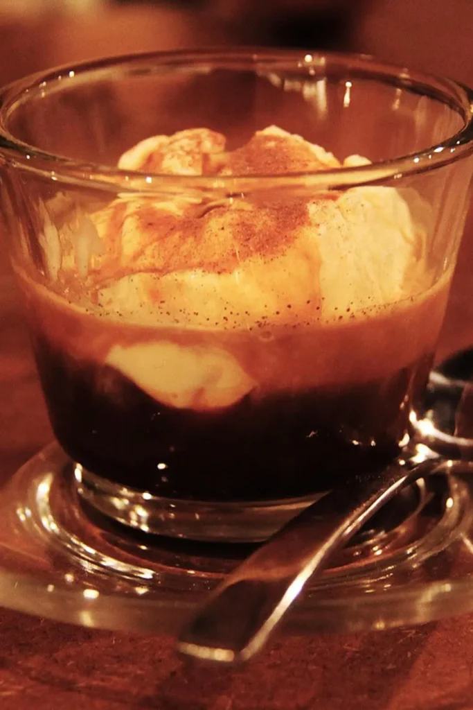 A creamy affogato with espresso poured over vanilla ice cream in a glass