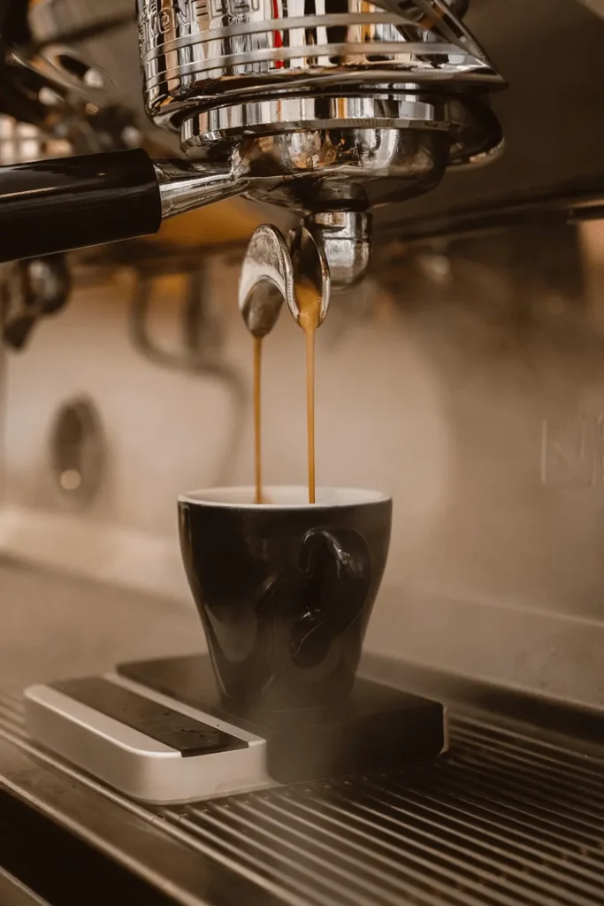 Coffee being extracted into a cup from an espresso machine