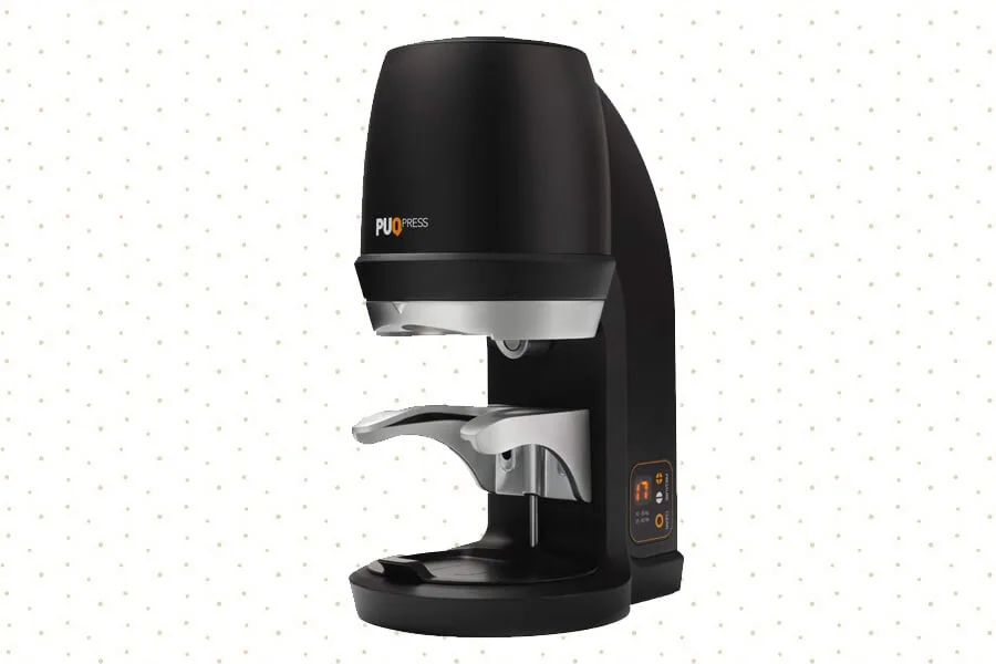 The PUQPress Gen 5 Q2 Automatic Coffee Tamper shown in a sleek, compact design on a kitchen counter.