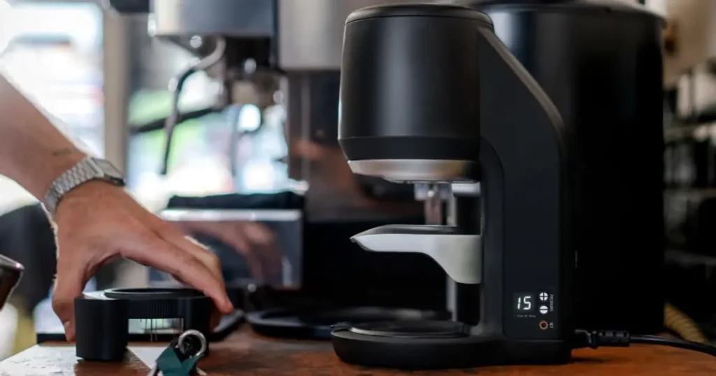 PUQPress Review: Is an Automatic Coffee Tamper Worth It? 56 PUQpress Mini Gen 6 automatic coffee tamper on a kitchen bench for espresso preparation