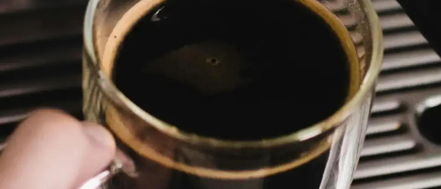 What Is an Americano? Taste, Recipe & Caffeine Guide☕ 2 A steaming cup of Americano coffee on a table, showcasing its rich color and smooth texture.