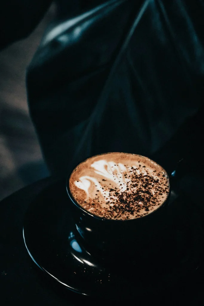 A rich cappuccino served in a sleek black cup with velvety milk foam