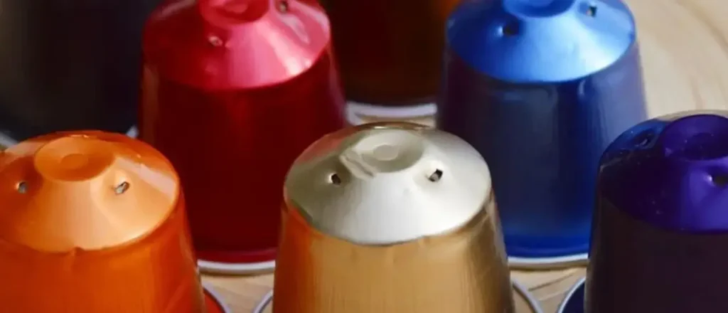 Nespresso Original vs Vertuo Capsules Explained (2026 Guide) 2 Assorted Nespresso Essenza coffee pods arranged on a counter