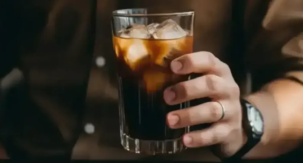Cold Brew Espresso - What It Is & How to Make It ❄️ 114 Man holding a glass of cold brew espresso, showcasing its dark, refreshing appearance.