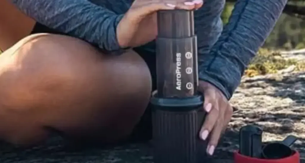 🧳 AeroPress Go Review: The Compact Brewer Made for Travel 69 Woman brewing coffee outdoors using the AeroPress Go