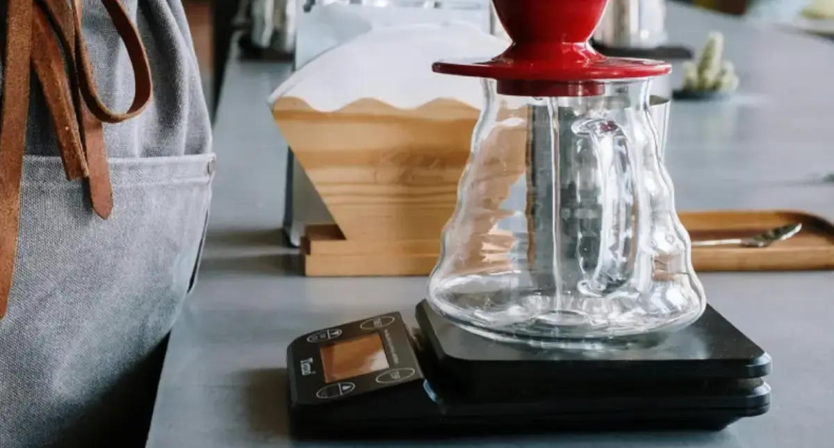Best Coffee Scales for Brewing Accuracy โ๐ 2 Barista weighing a coffee carafe on digital coffee scales for precise brewing accuracy