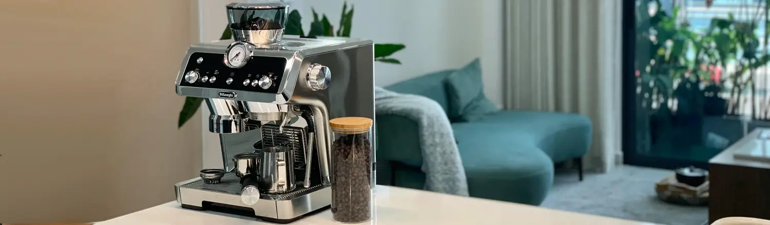 We Tested Espresso Machines From $100 to $1,000 — These 8 Pulled Perfect Shots ☕️ 2 Small espresso machine on a kitchen table with a container of coffee beans beside it