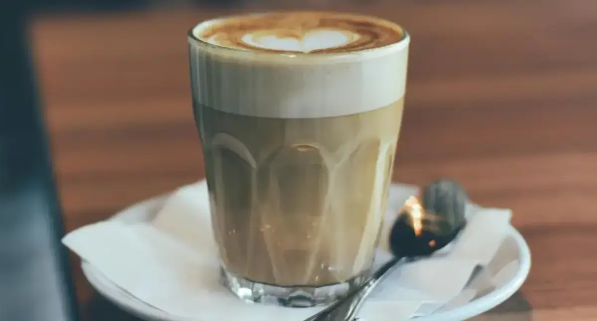 Cortado: The Smooth Spanish Espresso Drink You Need to Try 🇪🇸 2 A glass of cortado coffee with equal parts espresso and steamed milk, served on a café table