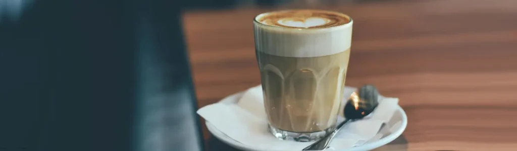 🇪🇸 Cortado: The Smooth Spanish Espresso Drink You Need to Try 111 A glass of cortado coffee with equal parts espresso and steamed milk, served on a café table