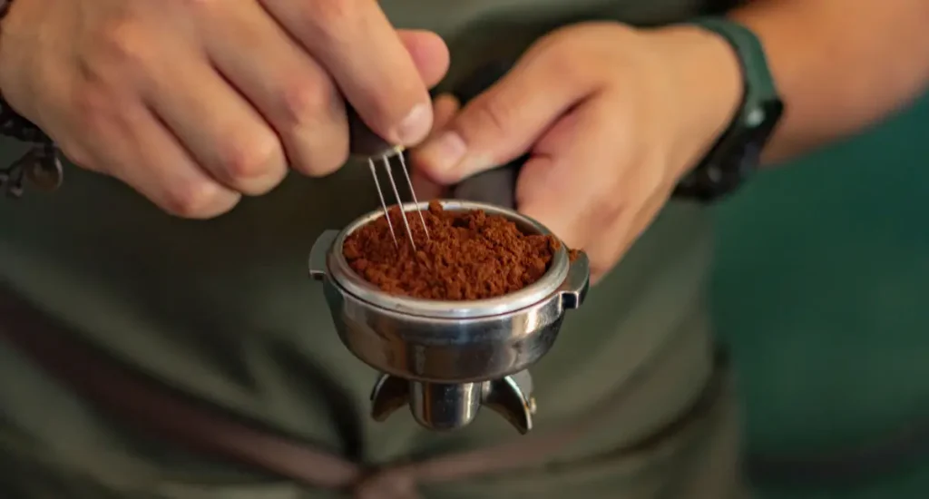 How to Use a WDT Tool for Espresso (Like a Pro) ☕ 85 Person using a WDT tool to distribute espresso grounds in a portafilter