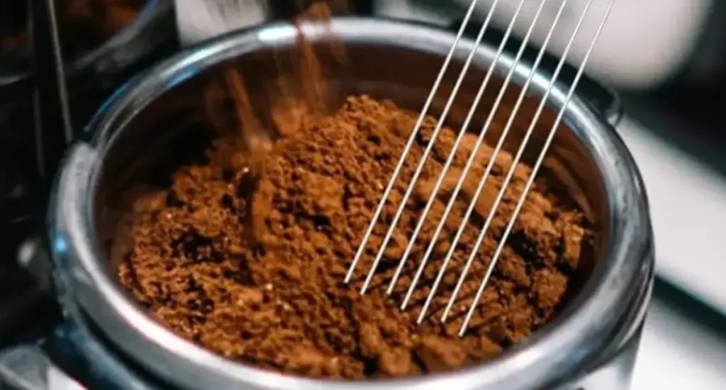 What is a WDT Tool? Your Beginner’s Guide to Better Espresso Shots 200 Person using a WDT tool to distribute espresso grounds evenly in a portafilter