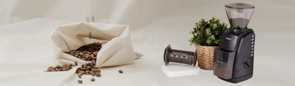☕ Baratza Encore Review: The Best Beginner Burr Grinder? 175 Baratza Encore grinder with a bag of coffee beans, AeroPress, and plant on a home coffee bar setup
