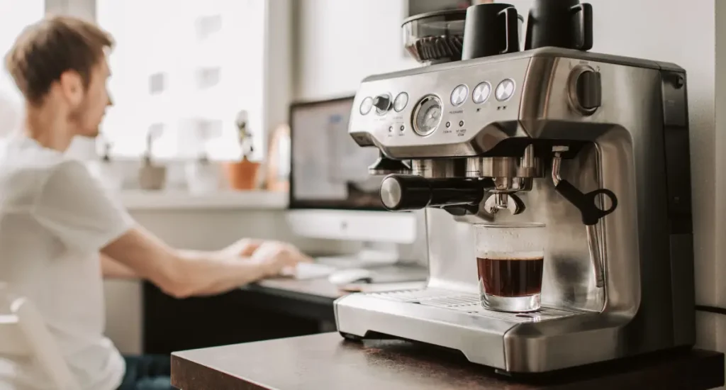 Best Espresso Machines Under $500 (Affordable Picks That Deliver) 💸 155 Close-up of a stainless steel espresso machine near a male working
