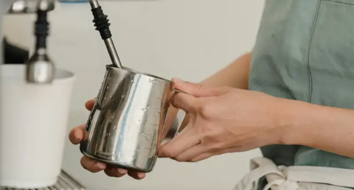 Best Milk Pitchers for Pouring Latte Art 🥛 2 Barista showing how to steam milk using a milk pitcher under a steam wand to create microfoam.