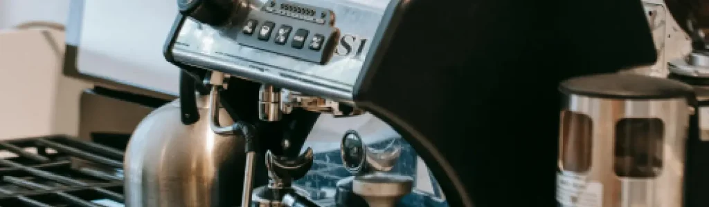 💸 Best Espresso Machines Under $500 (Affordable Picks That Deliver) 177 Close-up of a stainless steel espresso machine with a kettle and coffee dripper on the counter