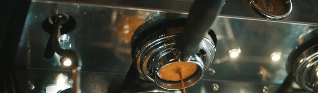 Troubleshooting Common Espresso Issues ☕️🛠️ 37 Close-up of espresso being extracted from a machine, viewed from below the group head