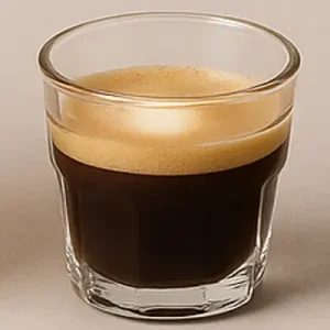 Macchiato Coffee with Frothy Milk Freshly brewed macchiato in a clear glass, topped with a swirl of frothy milk
