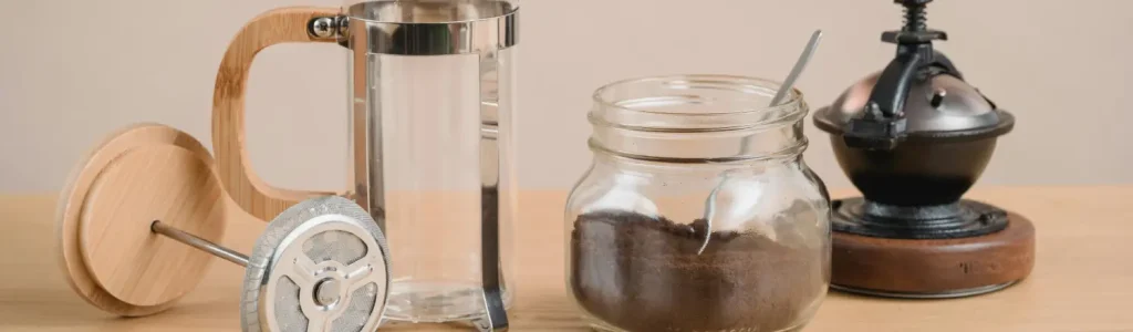 Best Coffee Accessories for Gifting 94 A selection of stylish coffee accessories including a mug, scale, and tamper arranged on a warm-toned countertop.