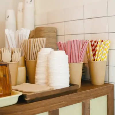 Eco-Friendly Coffee Gear β Sustainable Cups, Serviettes & Accessories Eco-friendly coffee items including reusable cups, compostable serviettes, and sustainable coffee accessories arranged on a table.