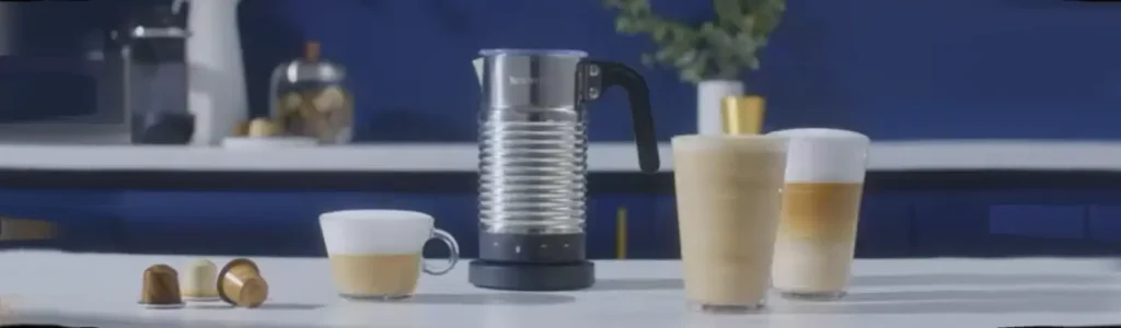Nespresso Aeroccino Milk Frother – Creamy Lattes at Home ☕✨ 105 Nespresso Aeroccino milk frother on a kitchen bench beside several cups of freshly made coffee.