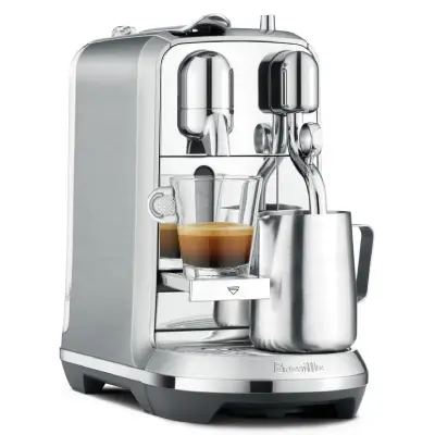 Nespresso Creatista Plus – Barista-Quality Lattes at Home Stainless steel Nespresso Creatista Plus espresso machine by Breville on a kitchen counter, with a latte and milk jug beside it