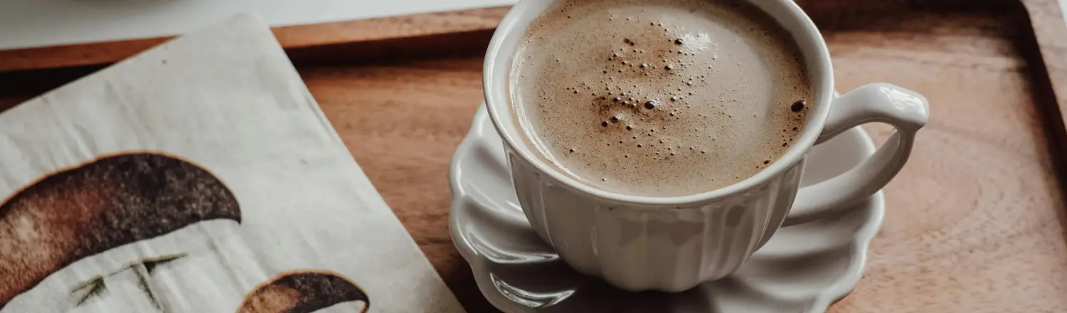 Best Mushroom Coffee Brands (2026): Top Picks Compared 2 Cup of mushroom coffee on a tray with fresh mushrooms displayed beside it