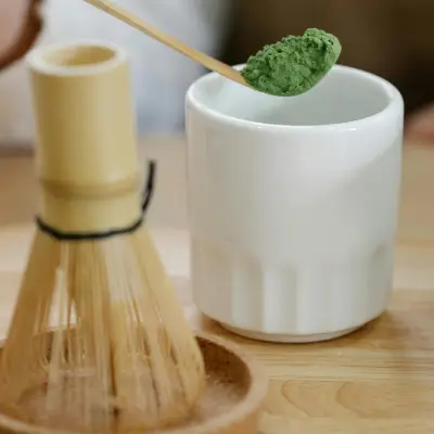 Best Ceremonial-Grade Matcha Powder for Lattes High-quality ceremonial-grade matcha powder in a tin with vibrant green tea powder displayed on a spoon.