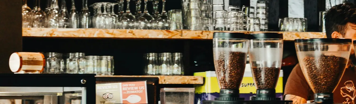 ✨ Coffee Accessories That Elevate Your Morning Ritual 2 A cozy home coffee bar shelf displaying glass mugs, cups, and accessories arranged neatly for a morning coffee ritual.