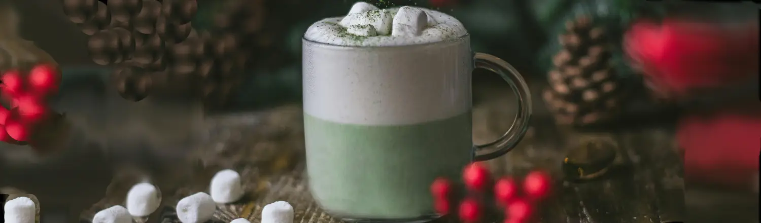 π΅ How to Make a Dalgona Matcha Latte at Home 2 A festive Dalgona Matcha Latte surrounded by marshmallows, baubles, and pine cones on a Christmas-themed table.