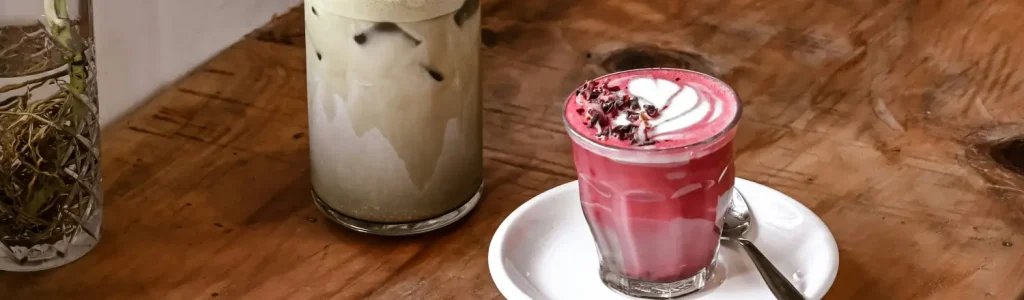 🌺 How to Make a Beetroot Latte at Home 73 Beetroot latte served beside a classic coffee latte on a table, showing the pink and brown contrast of two homemade café-style drinks
