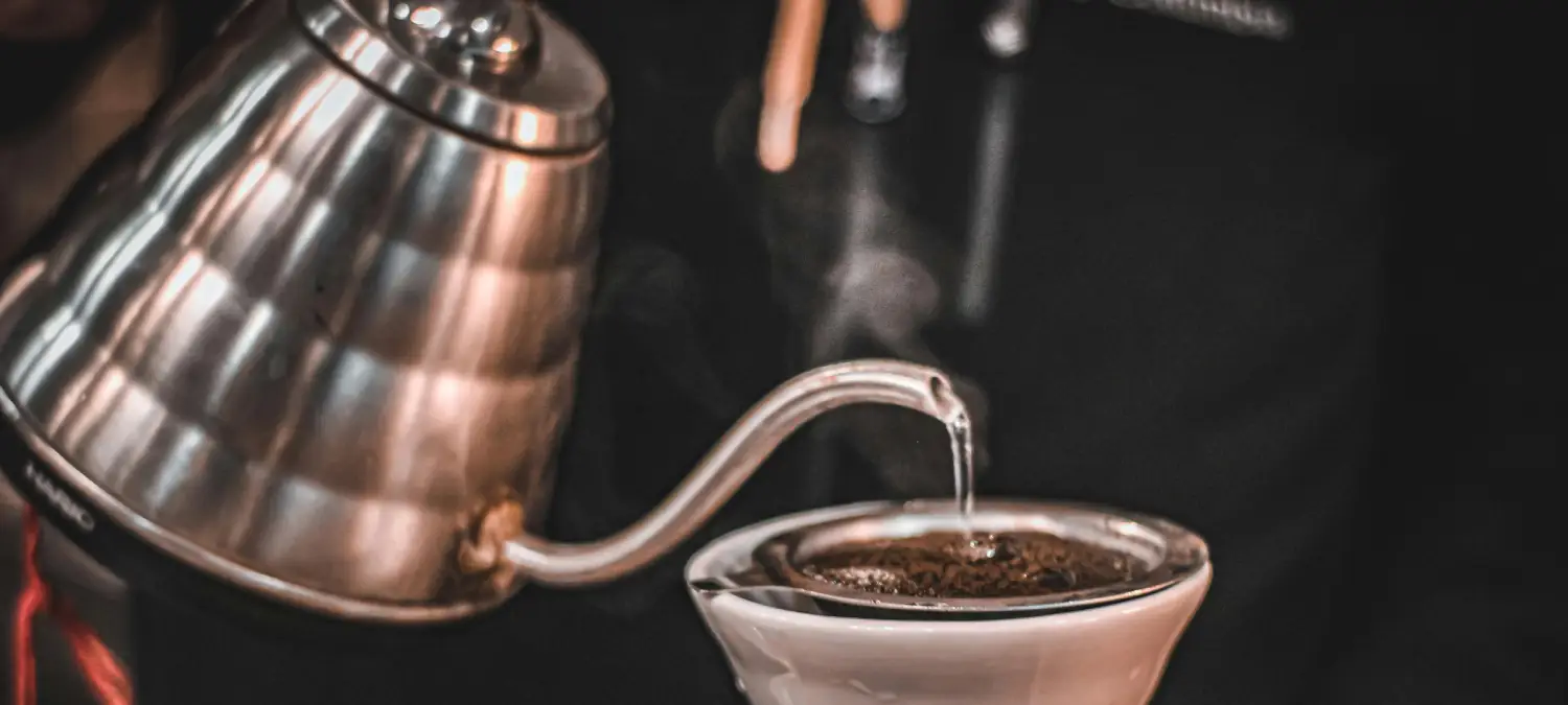 How to Use a Gooseneck Kettle Like a Pro ☕✨ 2 Person pouring hot water from a gooseneck kettle over coffee grounds during pour-over brewing