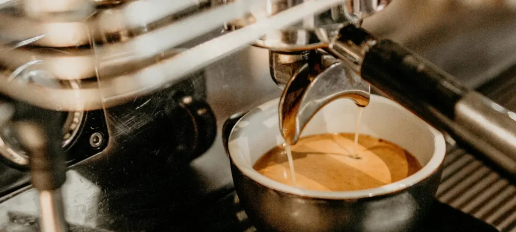 Manual Vs Automatic Espresso Machines: ☕ 95 Close-up of an espresso shot being pulled from a coffee machine for a manual vs automatic espresso machines comparison