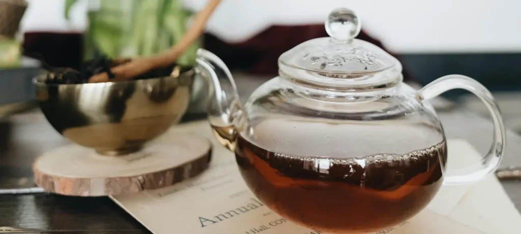 Best Tea Accessories for Every Tea Lover 🍵✨ 83 Glass teapot filled with tea alongside a bowl and spoon, showcasing essential tea accessories for tea lovers