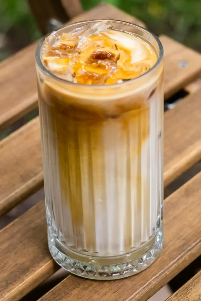 A refreshing cafe style iced latte in tall clear glass A refreshing cafe style iced latte in tall clear glass