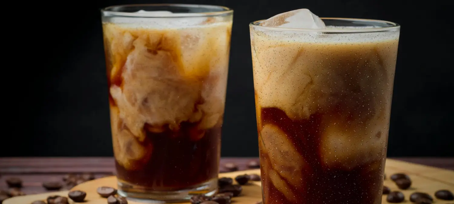 How to Make Café-Style Iced Lattes at Home ☕ 2 Two café-style iced lattes with espresso, milk, and ice served in clear glasses on a table