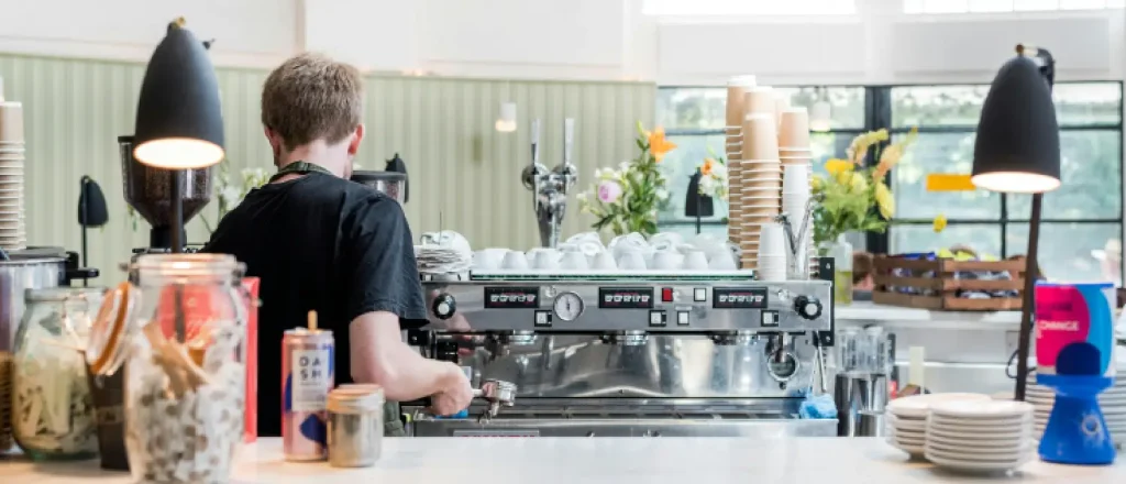 Home Espresso Workflows: Build a Better Coffee Routine 23 Home barista holding a portafilter while preparing espresso on a home espresso machine showing home espresso workflows