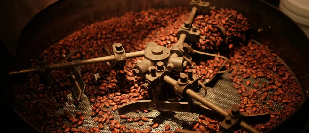 Light vs Medium vs Dark Roast: Coffee Roasting Guide 20 Coffee beans roasting inside a commercial coffee roaster showing how roasting affects coffee flavor profiles and aroma