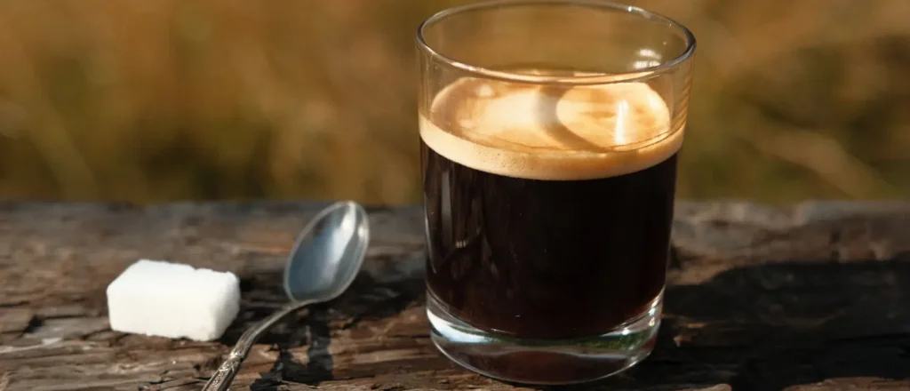 Triple Shot Americano: Caffeine & Taste Guide☕ 8 Triple Shot Americano in a white cup on a wooden table