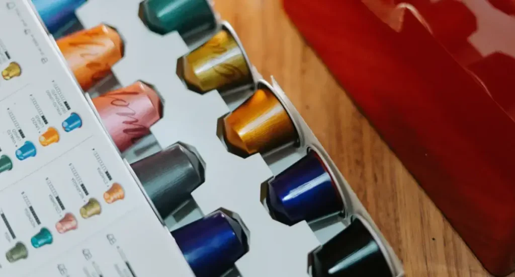 Best Nespresso Capsules Ranked: Find Your Perfect Pod ☕✨ 40 Red Nespresso coffee machine with an open box of assorted Nespresso capsules ready for brewing espresso representing the Best Nespresso Capsules